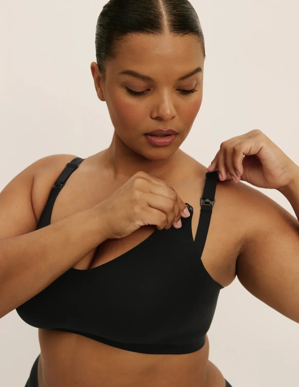 Front view of model wearing the Revolution Nursing Bra, highlighting the neckline, nursing clip strap design, and smooth silhouette – Black – view 9 of 21