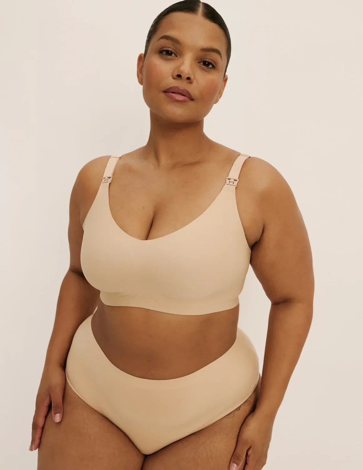 Front view of model wearing the Revolution Nursing Bra, highlighting the neckline, nursing clip strap design, and smooth silhouette – Warm Sand – view 1 of 21