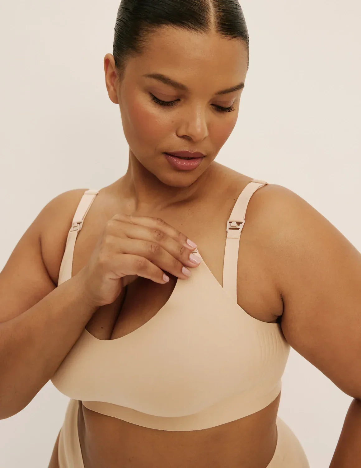 Front view of model wearing the Revolution Nursing Bra, highlighting the neckline, nursing clip strap design, and smooth silhouette – Warm Sand – view 8 of 21