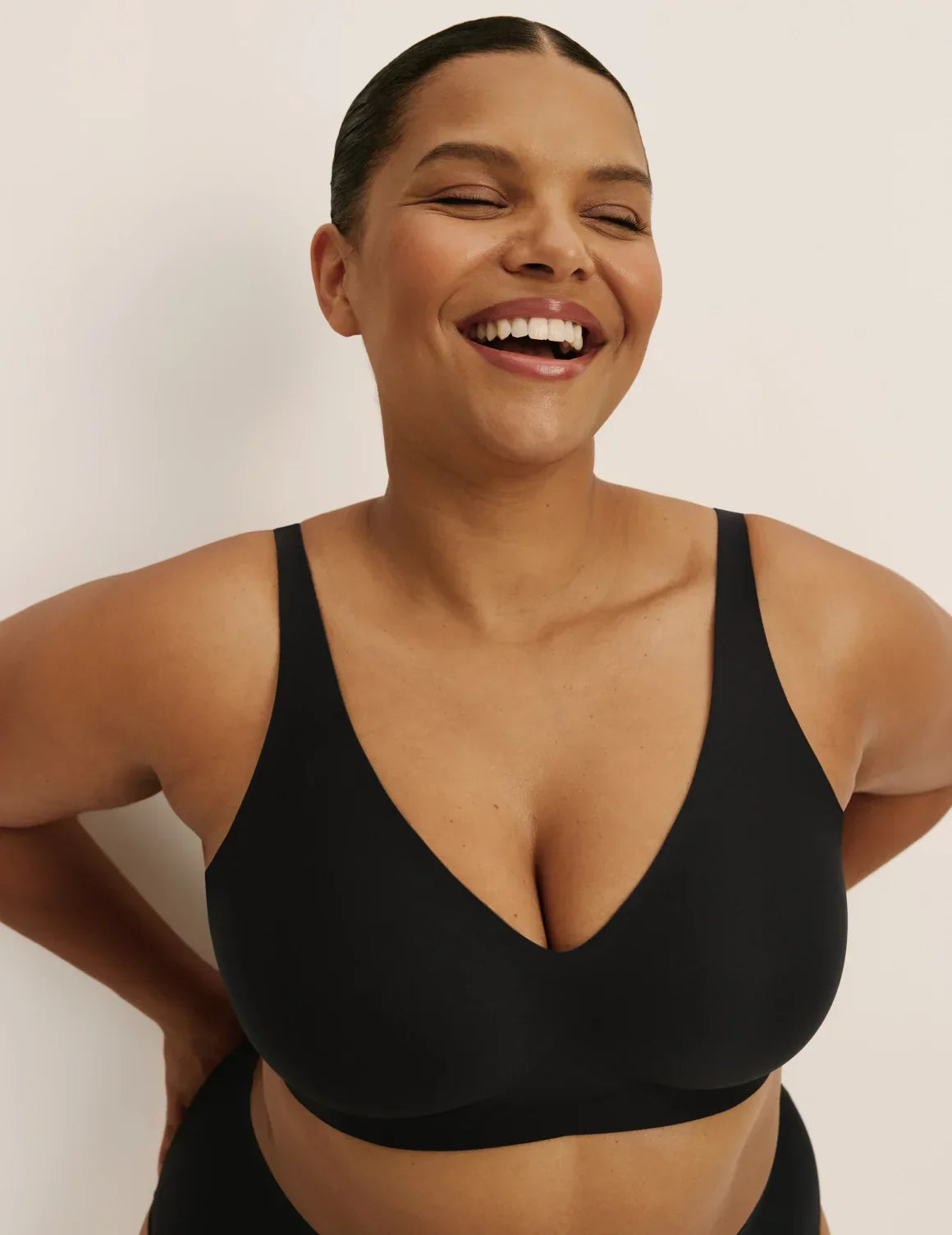 Front view of model wearing the Revolution V-Neck Bra, highlighting the neckline, strap design, and smooth silhouette – Black – view 2 of 50