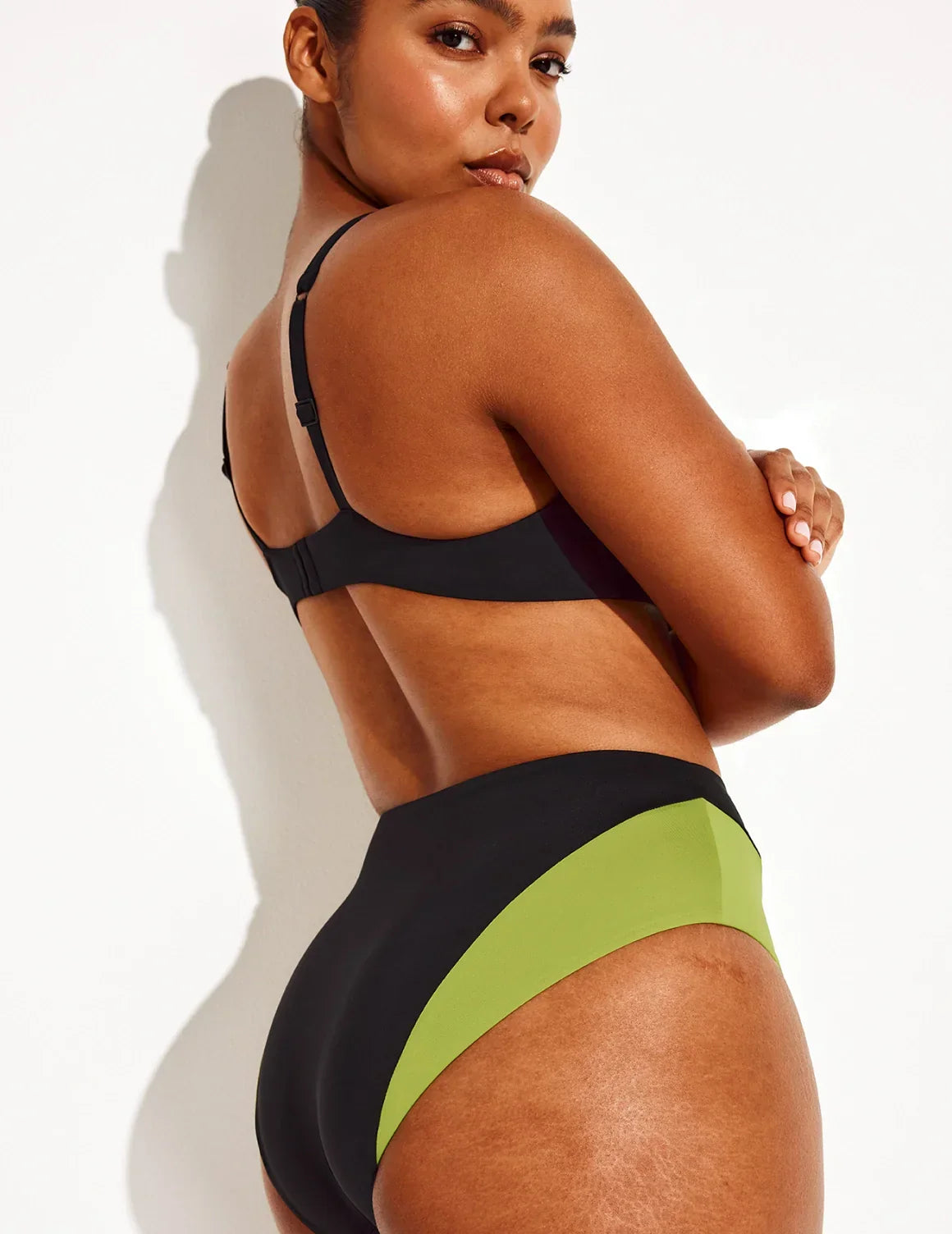 Side view of model wearing the Ruched Deep V Bikini Top, highlighting the neckline, strap design, and silhouette – Black – view 9 of 18