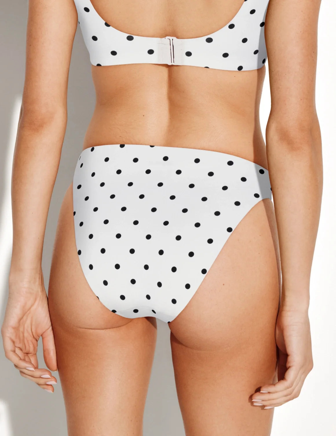 Back view of model wearing the Sculpt High Cut Bikini Swim Bottom highlighting the coverage and fit – White with Black Polka Dot – view 12 of 40