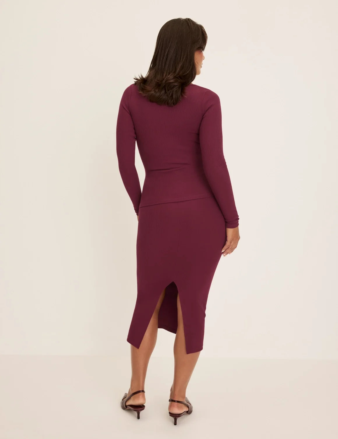 Back view of model wearing the SculptRib™ Cotton Midi Pencil Skirt highlighting the hemline, fabric and hugging fit – Dark Cherry – view 8 of 23
