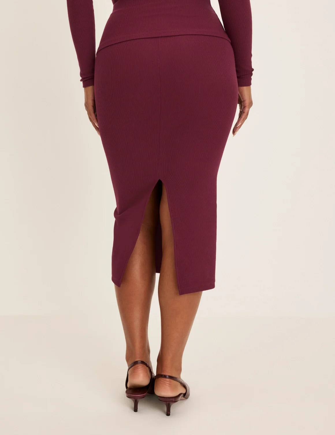 Back view of model wearing the SculptRib™ Cotton Midi Pencil Skirt highlighting the hemline, fabric and hugging fit – Dark Cherry – view 9 of 23