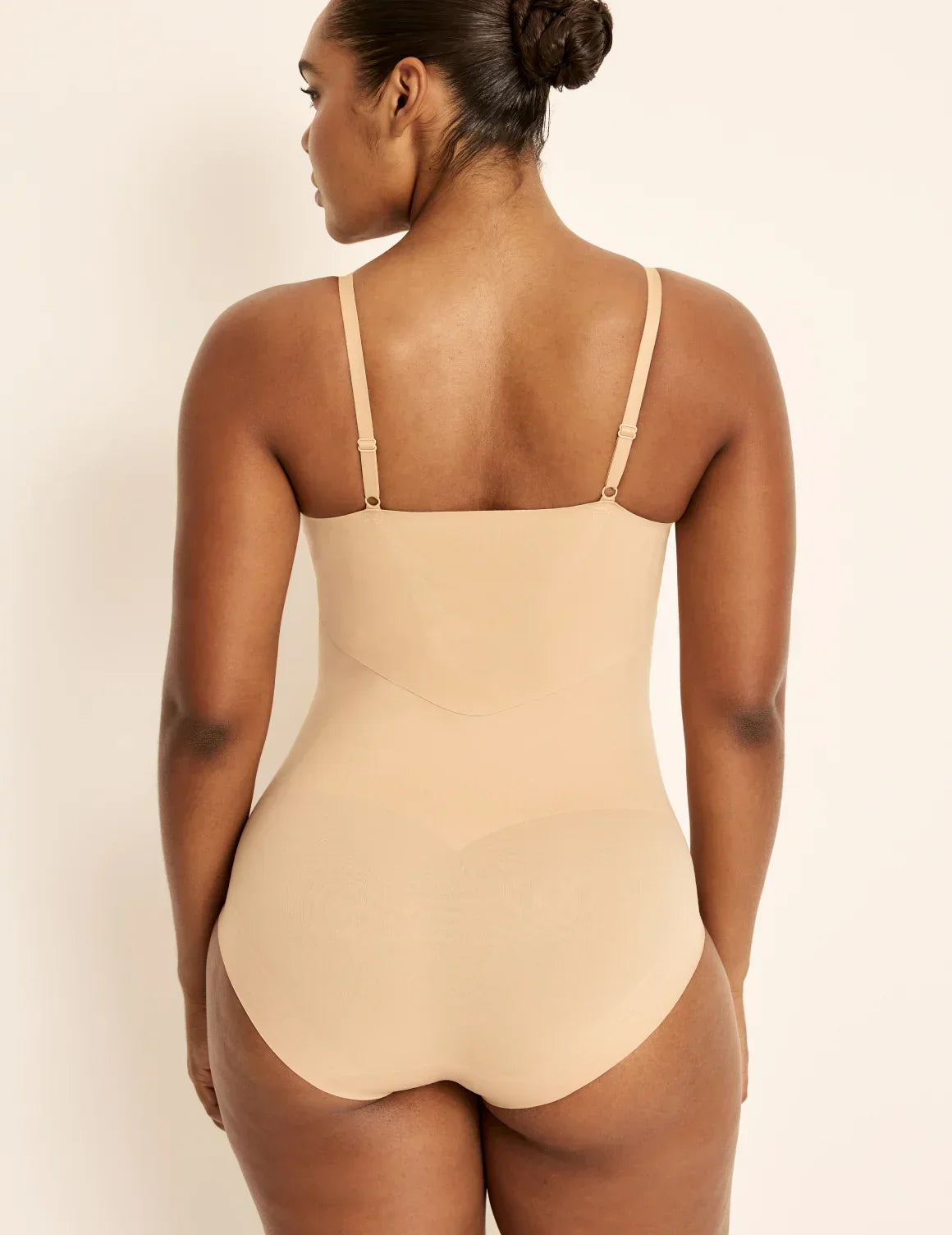 Side view of model wearing the Customizable Shaper Bodysuit highlighting the coverage and smooth fit – Warm Sand – view 9 of 13