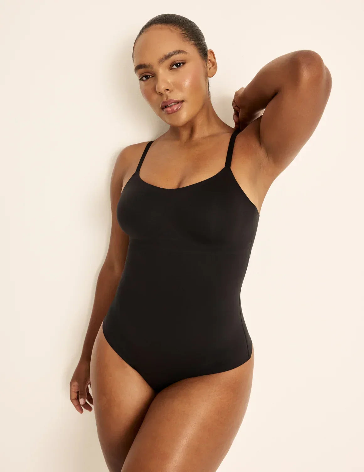 Front view of model wearing the Customizable Shaper Thong Bodysuit highlighting the coverage and smooth fit – Black – view 1 of 15
