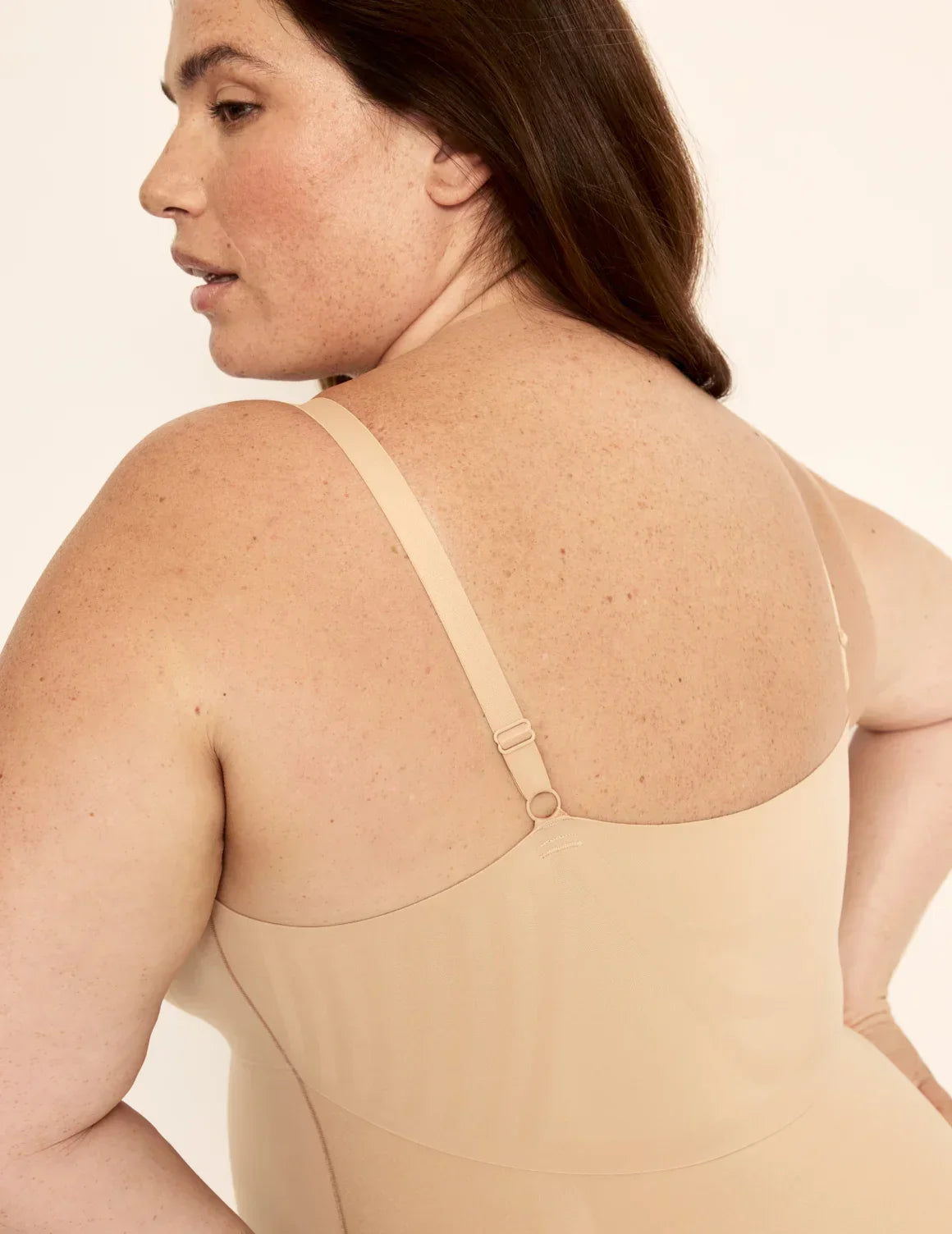 Back view of model wearing the Customizable Shaper Thong Bodysuit highlighting the coverage and smooth fit – Warm Sand – view 12 of 15