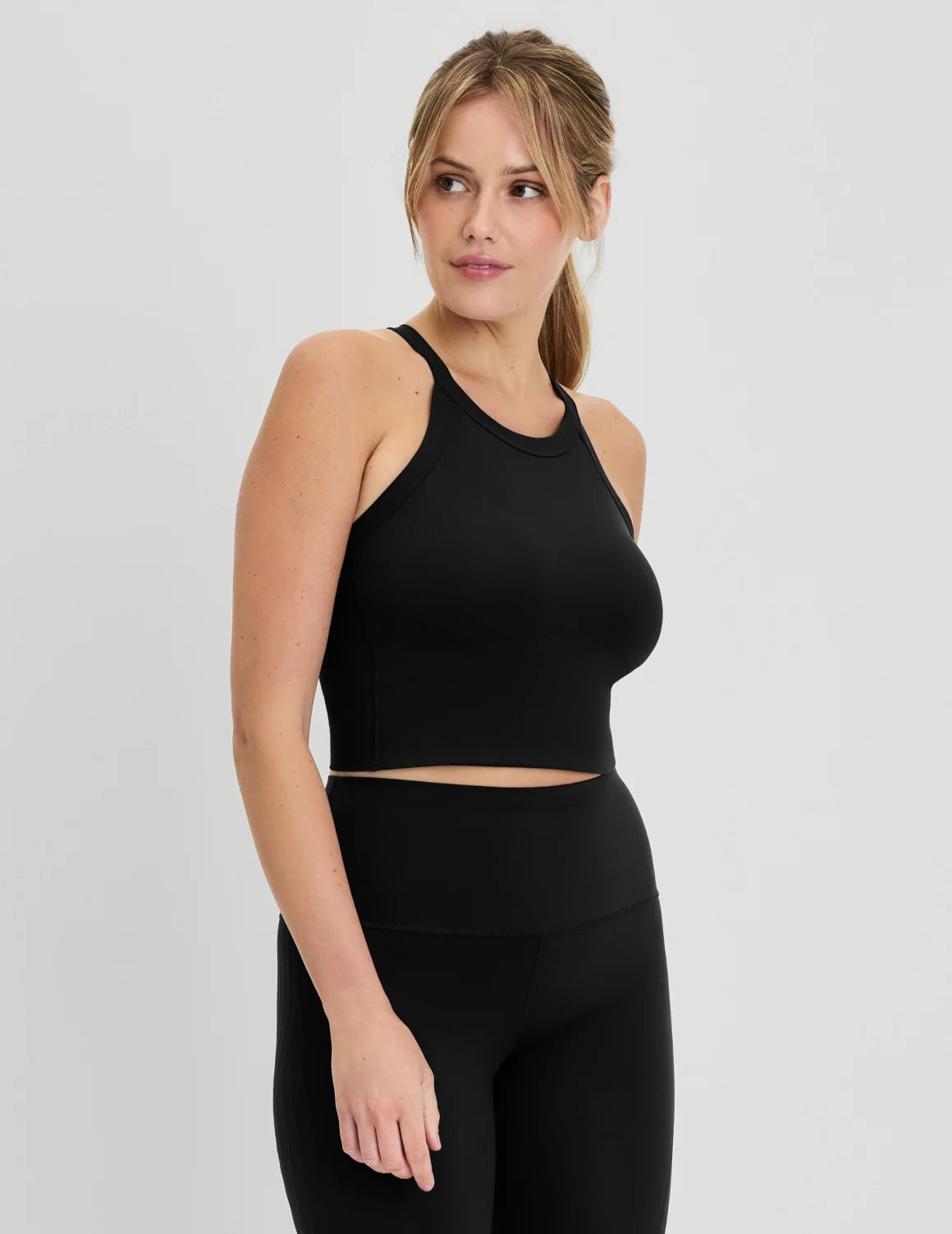 Full-body view of model wearing the Studio Ribbed Bra Top, highlighting the neckline, design, and silhouette – Black – view 4 of 19