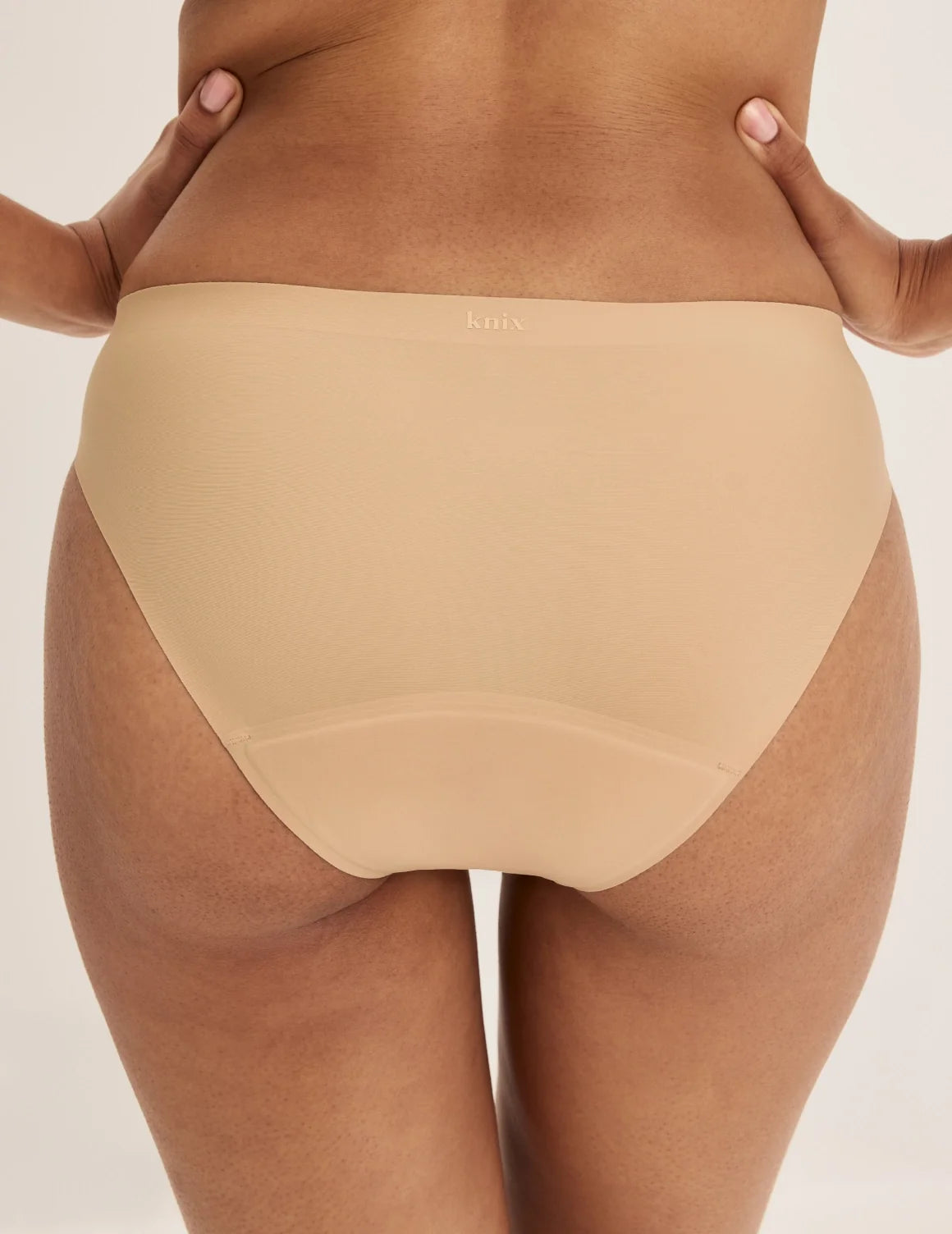 Back view of model wearing the Super Leakproof® No-Show Bikini highlighting the coverage and smooth fit – Warm Sand – view 9 of 29